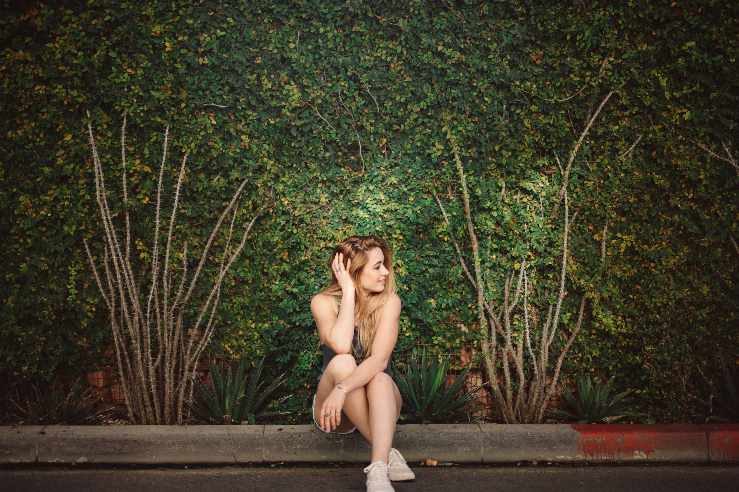 Artistic Bloggers Venice Beach Uncreative Blog Woman with long blond hair posing for the camera looking to the side sitting on a curb