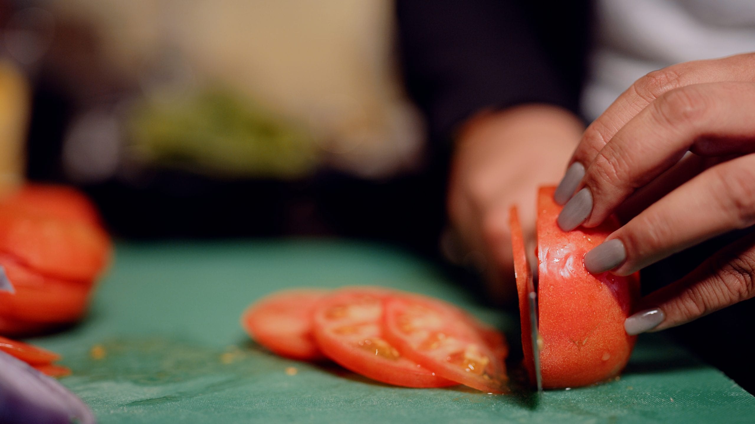 IU C&I Studios Portfolio Jeepney NYC Filipino BBQ Pop Up Restaurant Closeup of tomato being sliced by a female chef