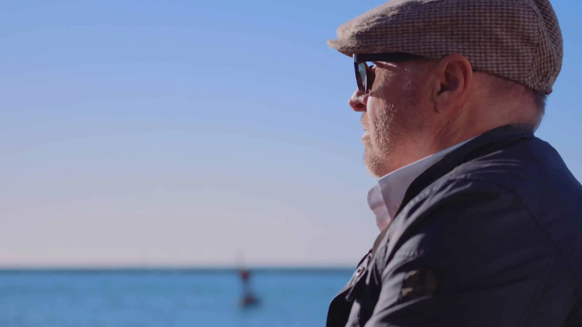 cis-portfolio-beltempo6 Side view of man wearing brown cap and navy blue jacket looking over the ocean