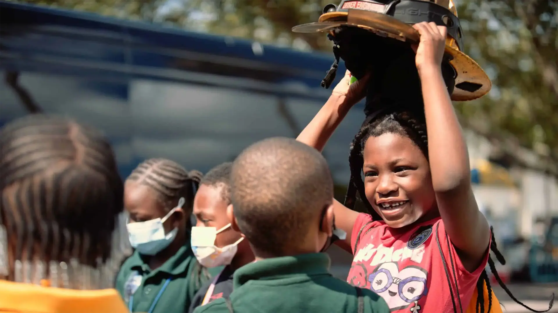 Ranger Technical Resources 37 African American boy taking off the fire helmet while another looks on with children around them