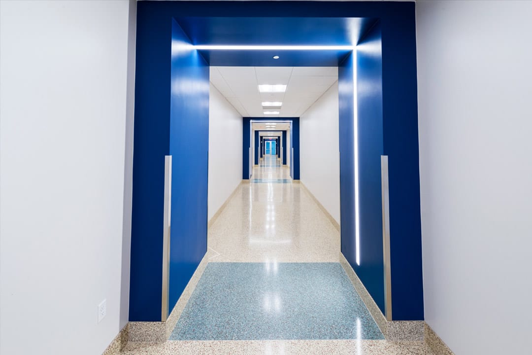 IU C&I Studio Portfolio Grycon Nova Southeastern View looking down a long white and blue hallway