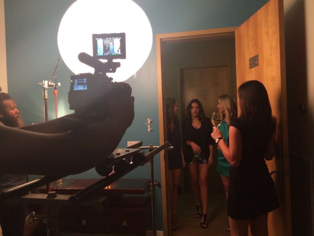 Blue Nun Four women standing in a doorway being filmed by a video cameraman