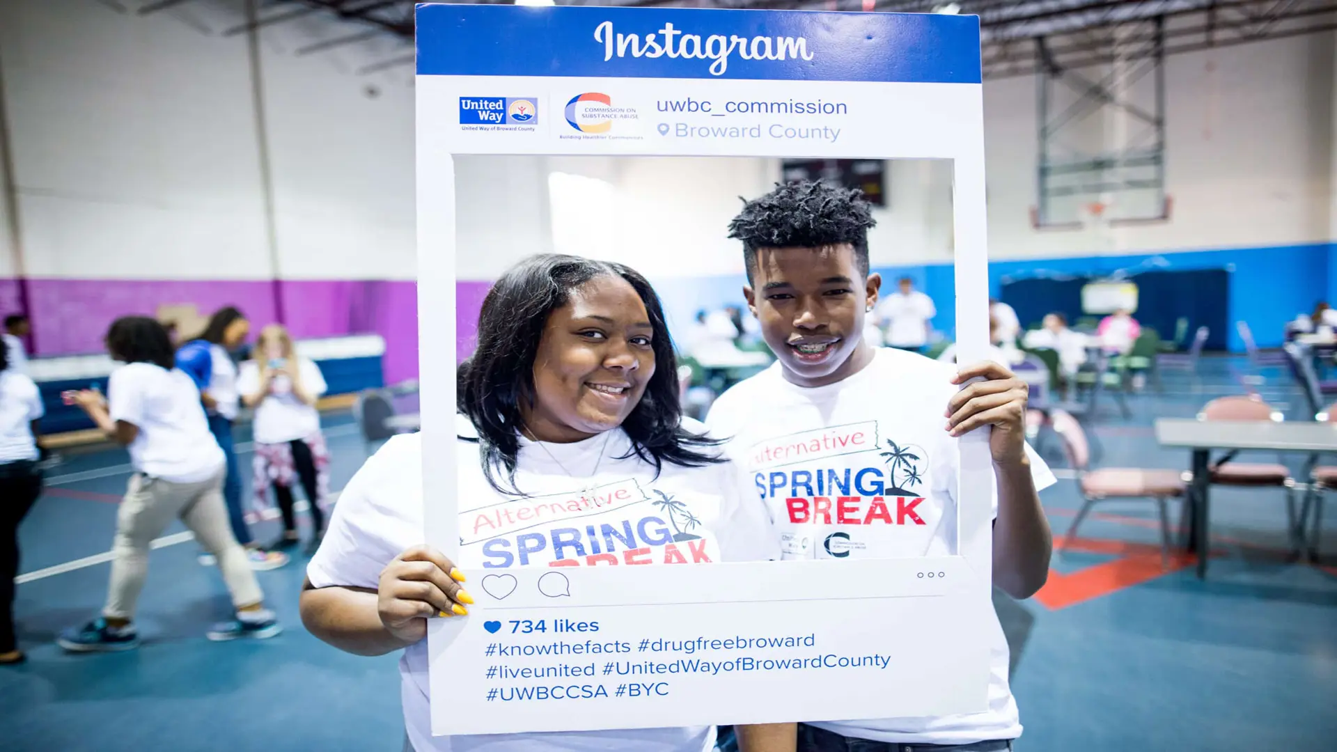 United Way 223 Man and woman posing for camera holding an Instagram item