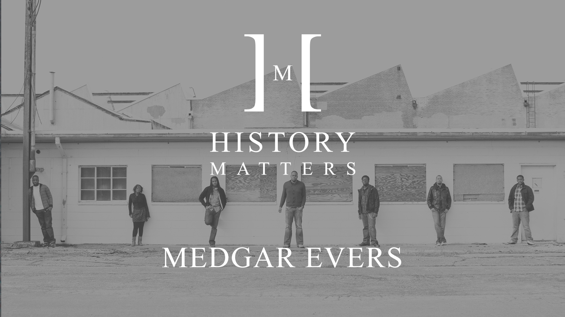 History Matters Medgar Evers Black and white background of six men and a woman posing for the camera in front of a building