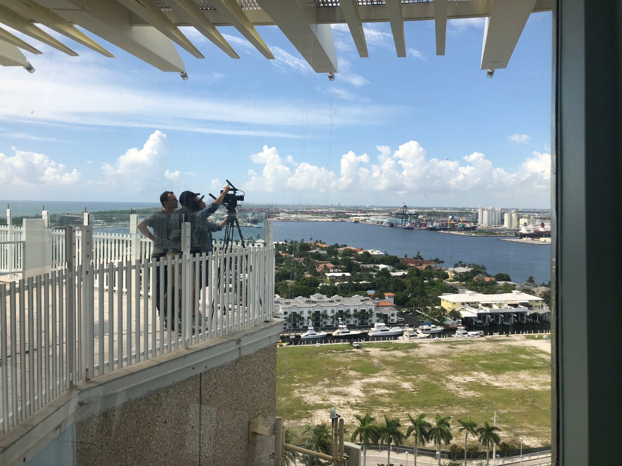 C&I Studios Go Pro Video cameraman setting up equipment on a platform overlooking the city and yacht club