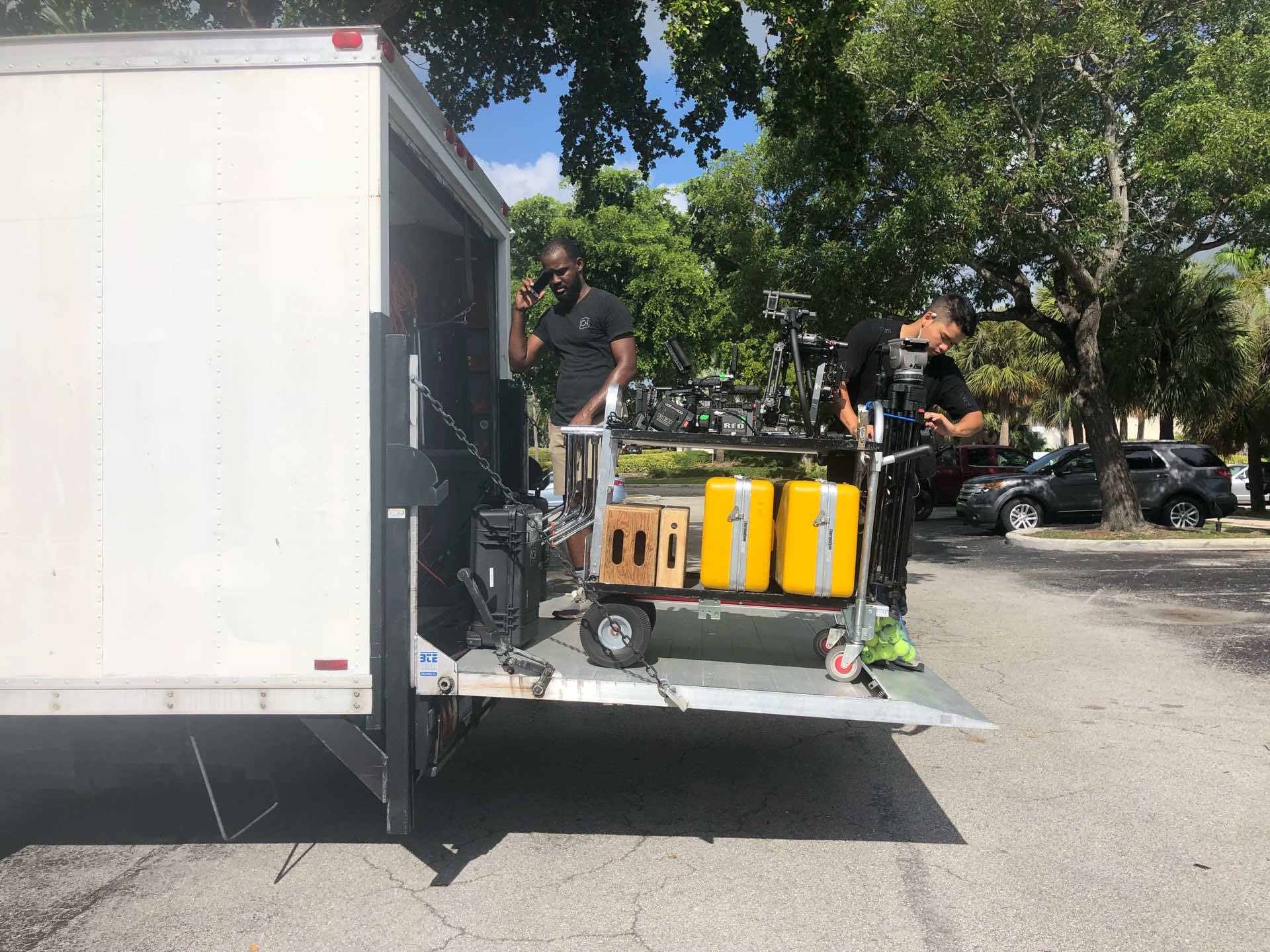 Behind the scenes Two C&I Studios cameramen loading video equipment onto a truck