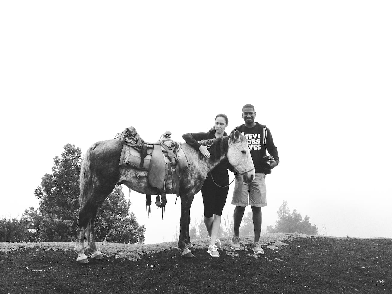 Black and white of Amy Joy Miller Producer C&I Studios standing with a man holding a camera and a horse