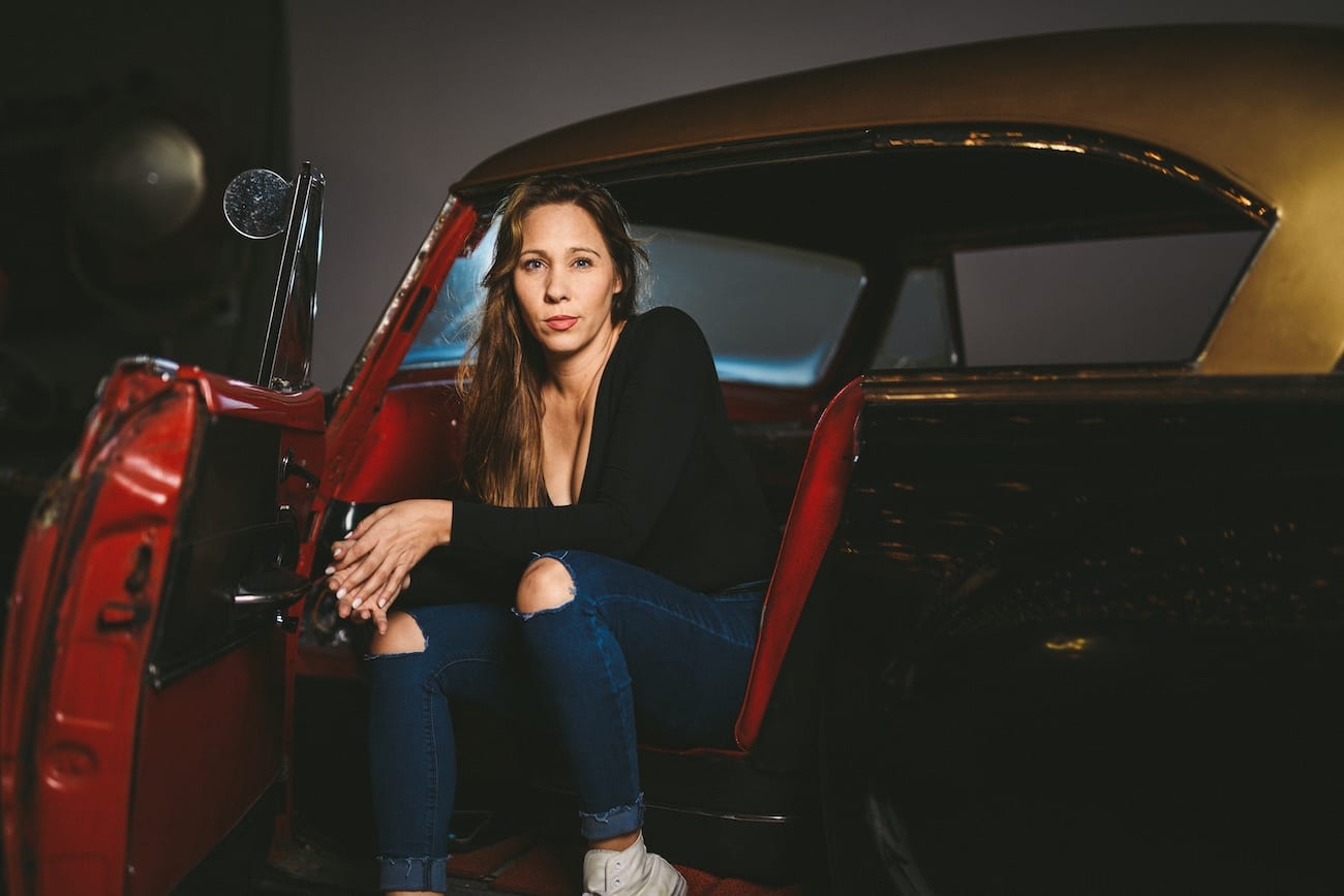 Amy Joy Miller Producer C&I Studios posing for camera sitting in a vintage car