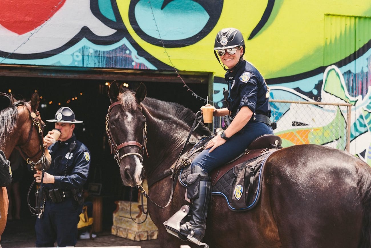 Female Police horseback rider outside Brew Urban Cafe smiling for camera
