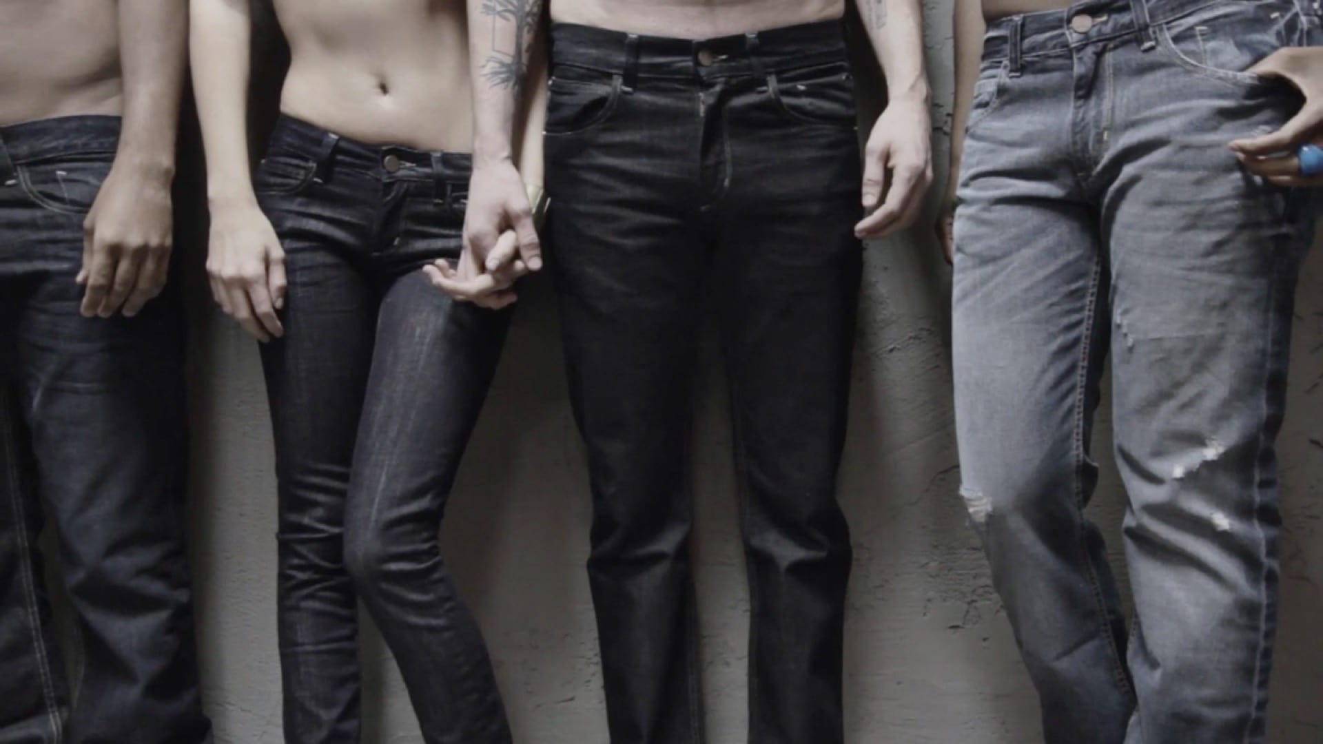 Group of men and a woman posing their jeans for camera