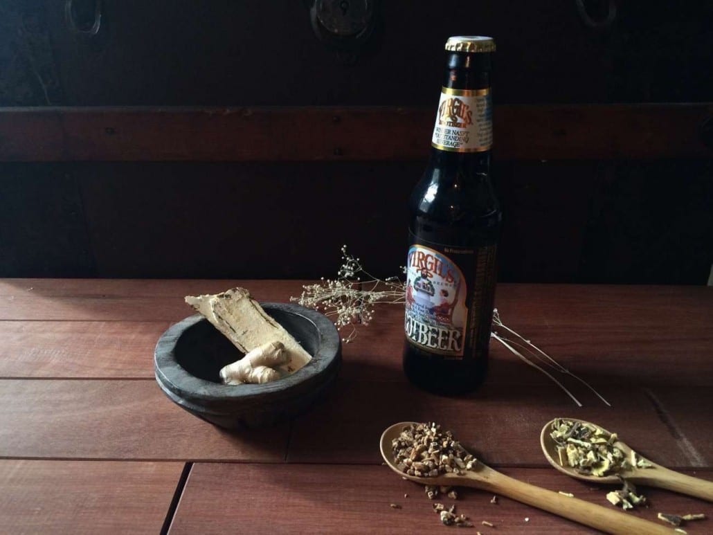 Reeds Closeup of bottle of Virgil's Root Beer surrounded by herbs on a wooden table