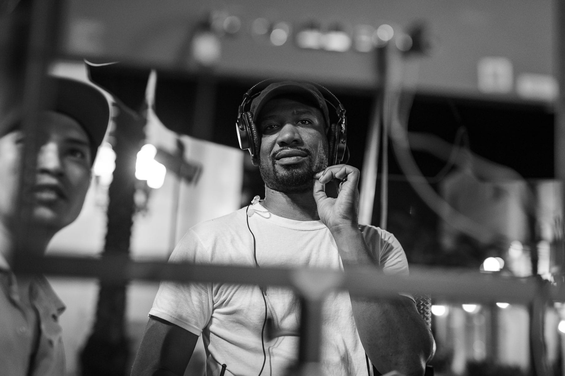 Two men including Joshua wearing headphones doing work in the studio