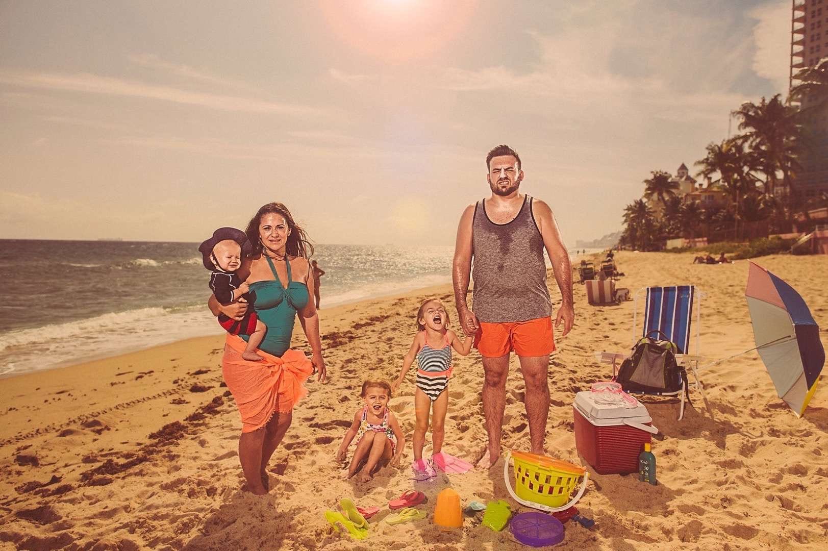 A Series of Unfortunate Family Portraits showing a family with three small children on the beach with beach related items.