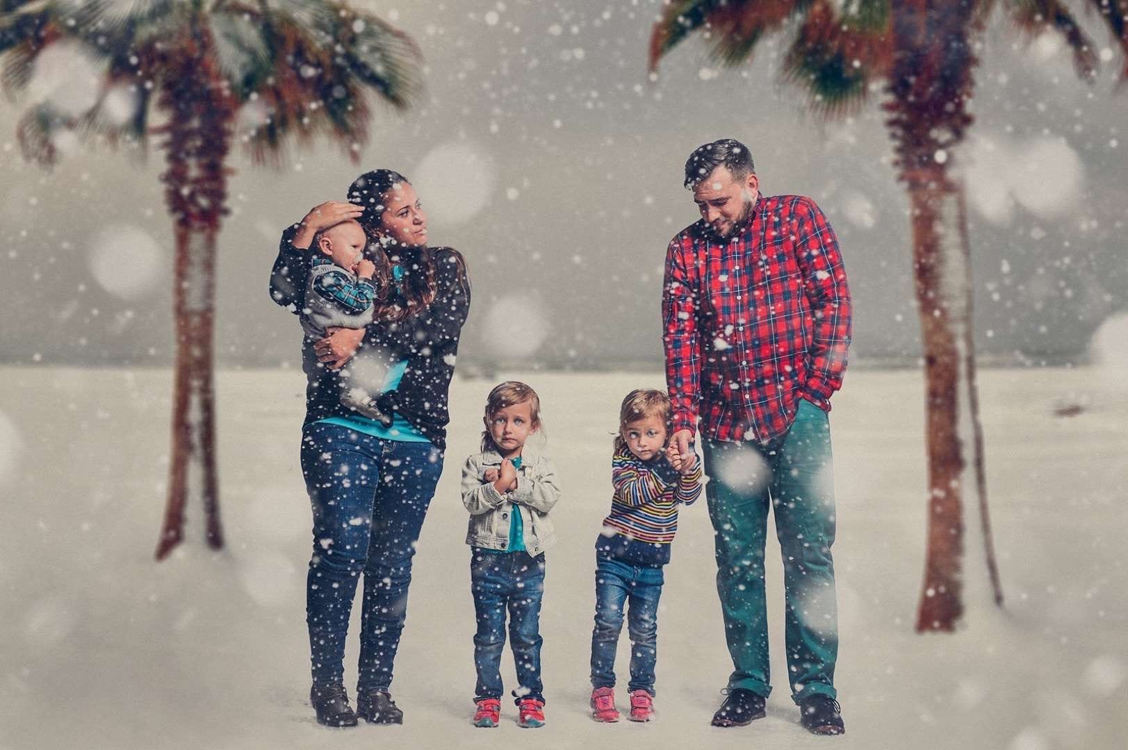A Series of Unfortunate Family Portraits showing a family with three small children by a beach in the winter with snow falling all looking cold.