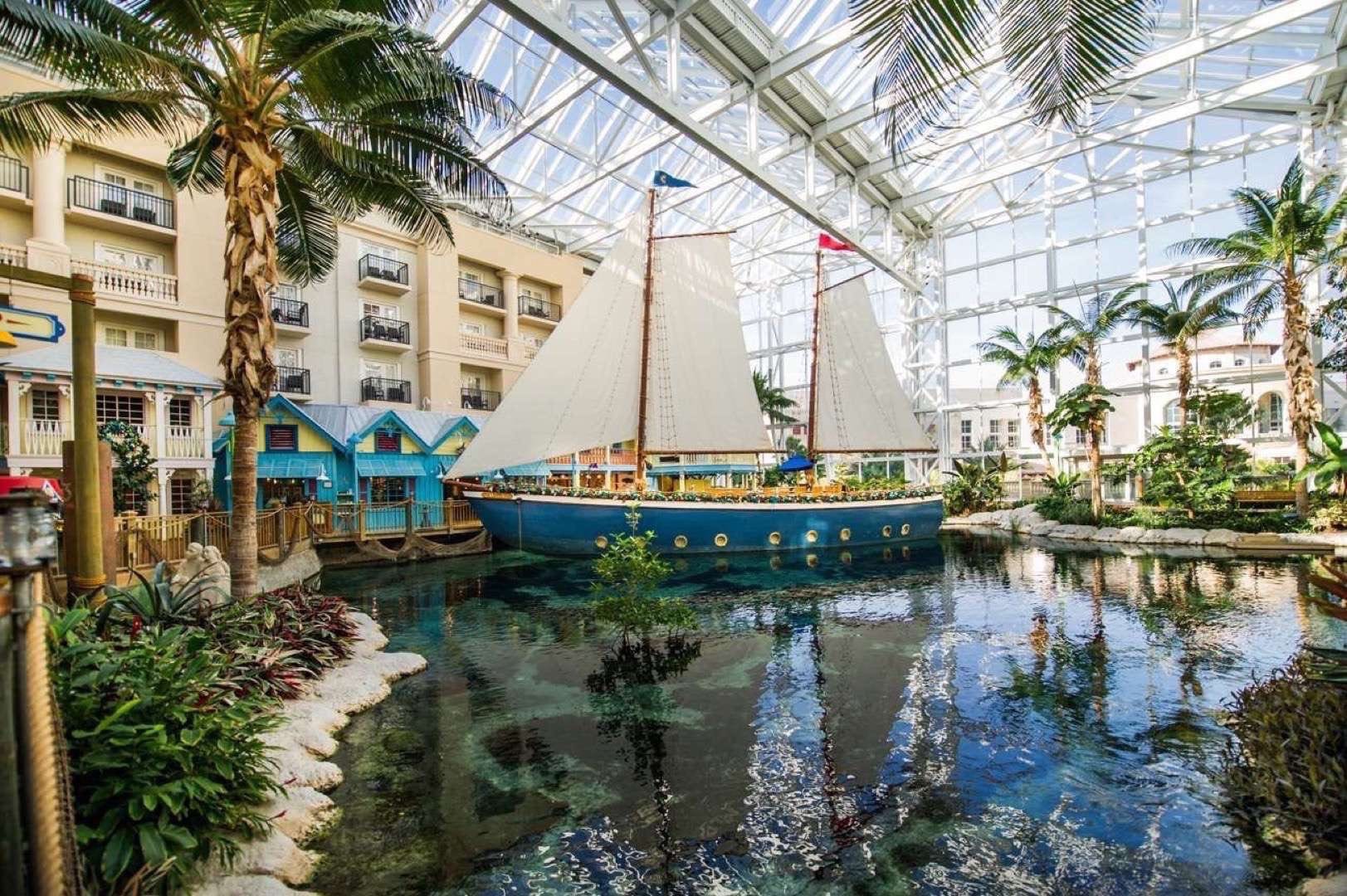 View at Gaylord Palms Resort and Convention Center overlooking a ship on the lake surrounded by palm trees and trees.