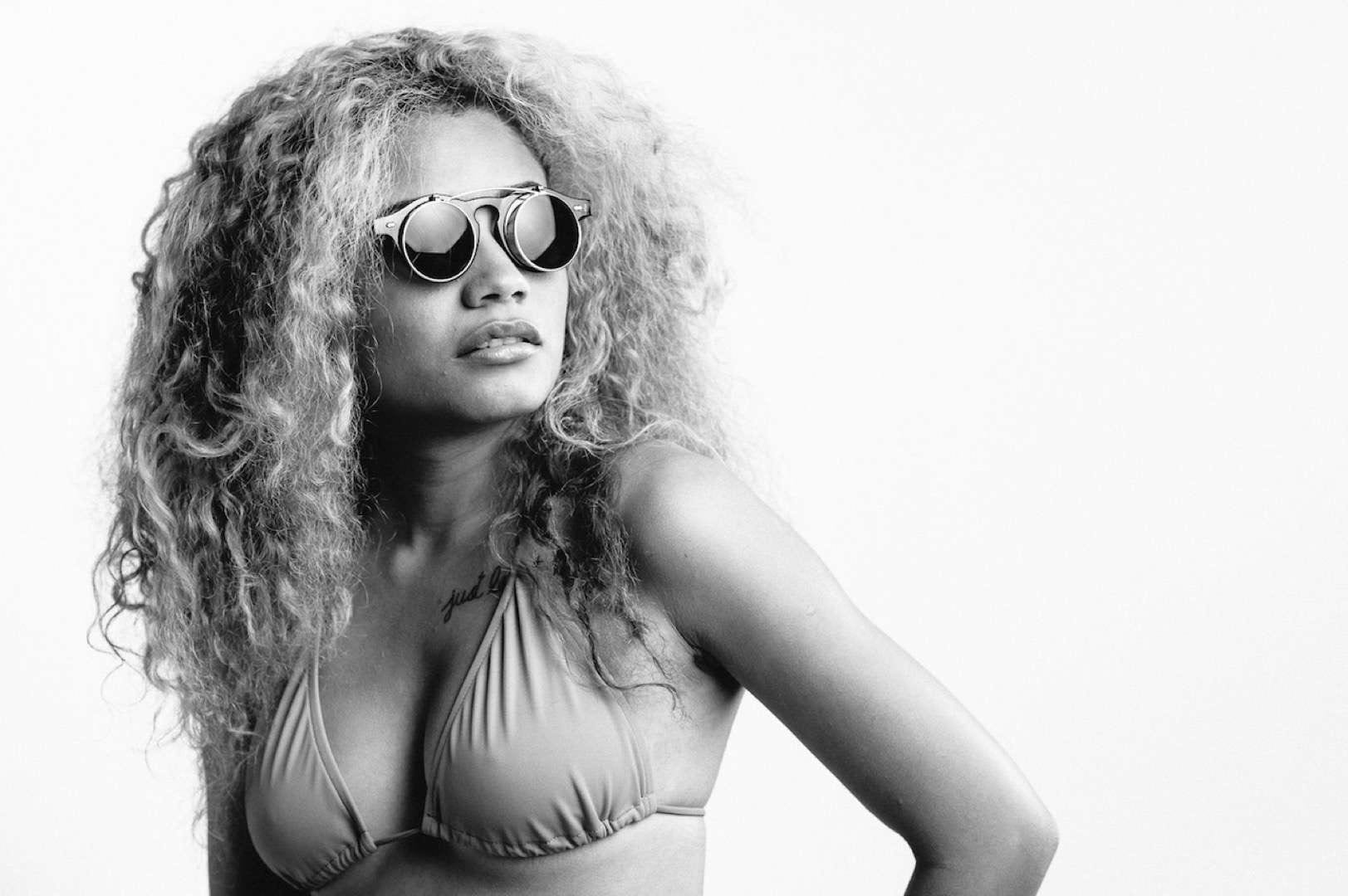 The Things We Did Last Summer Black and white of woman with long curly hair in a bikini wearing sunglasses looking off to side