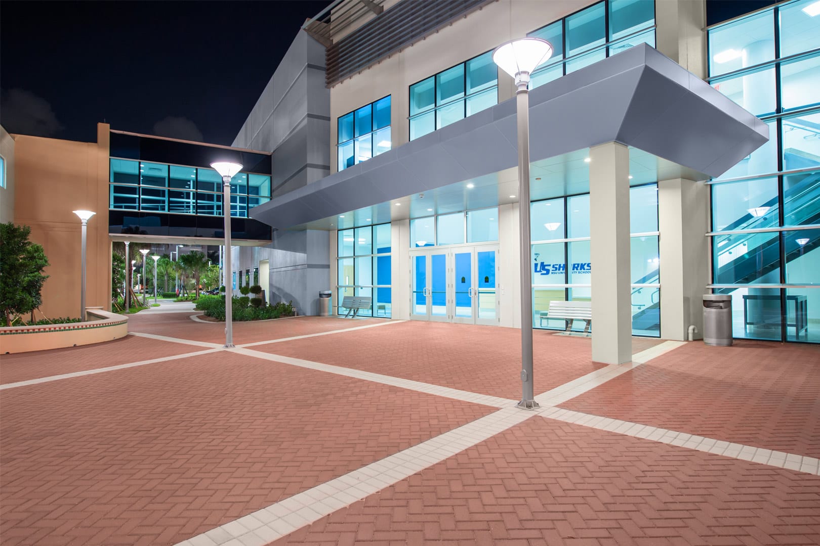 IU C&I Studio Portfolio and Page Grycon Nova Southeastern University View from outside of lobby of NSU University School by front doors with red bricked patio stones and lighting.