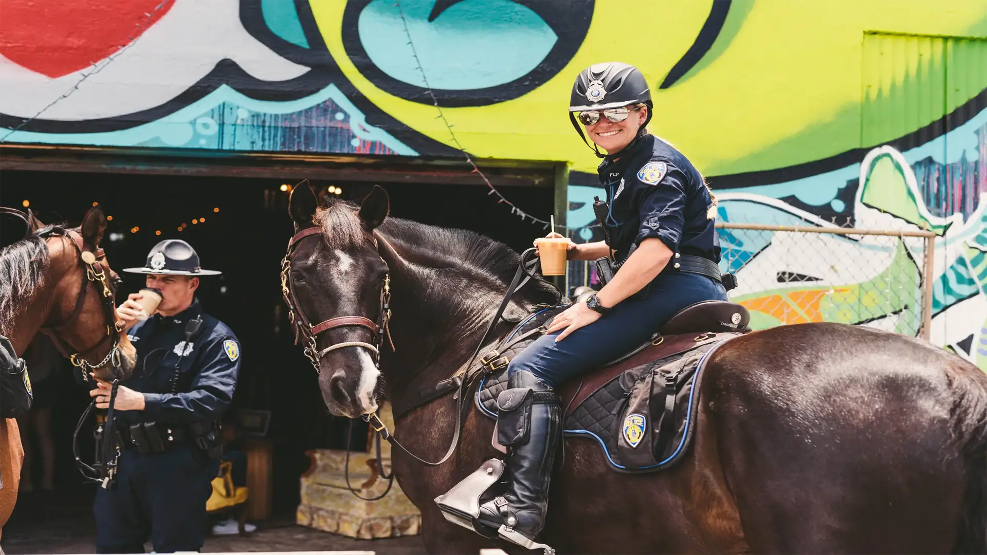 post-next-door-bay-doors2 Female Police horseback rider outside Brew Urban Cafe smiling for camera by the railroad tracks.