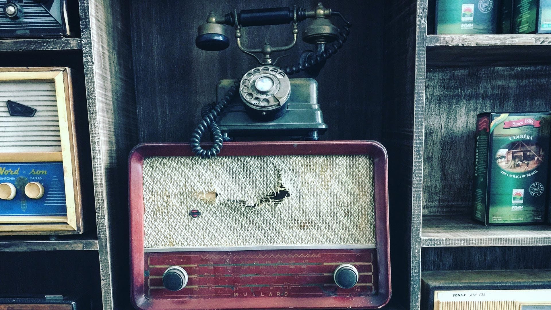 Shelving with old radios and an old telephone