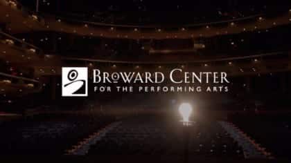 White Broward Center for the Performing Arts logo with a lit lightbulb on a stage.