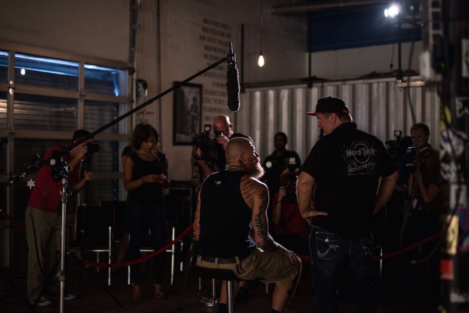 Tattooed man with mohawk talking to crew member