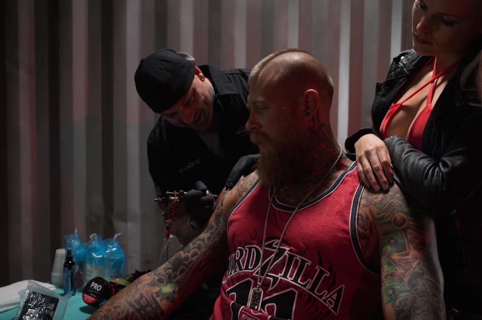 IU C&I Studios Portfolio Hard Rock Energy BTS Tattooed man with mohawk getting tattooed by tattoo artist