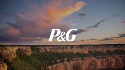 White Proctor & Gamble logo with beautiful view of a canyon with pink colored clouds in the light blue sky