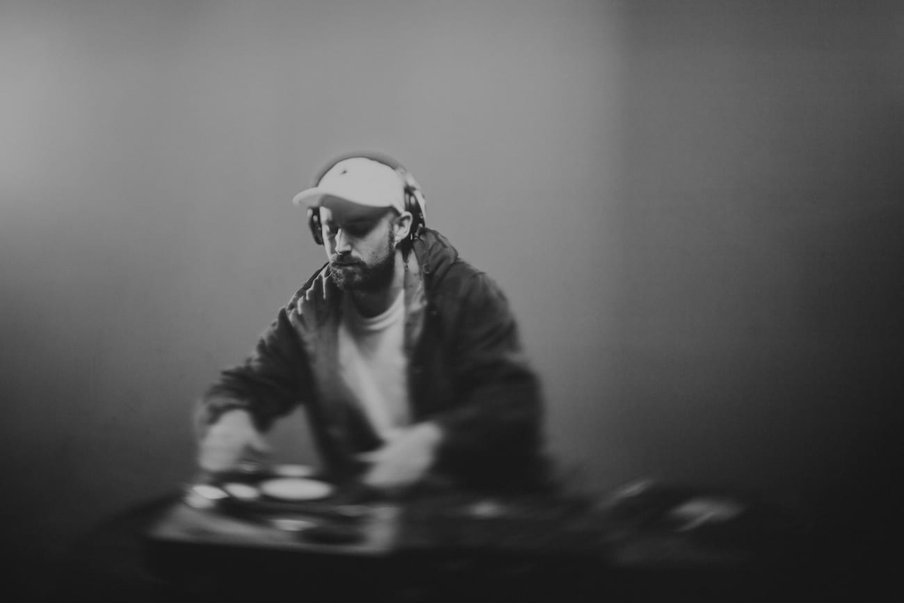 Facebook Live Video Black and white of a DJ wearing headphones doing DJ work