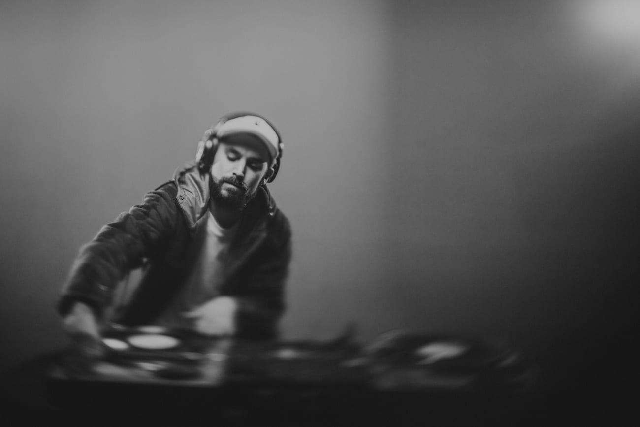 Facebook Live Video Black and white of a DJ wearing headphones doing DJ work