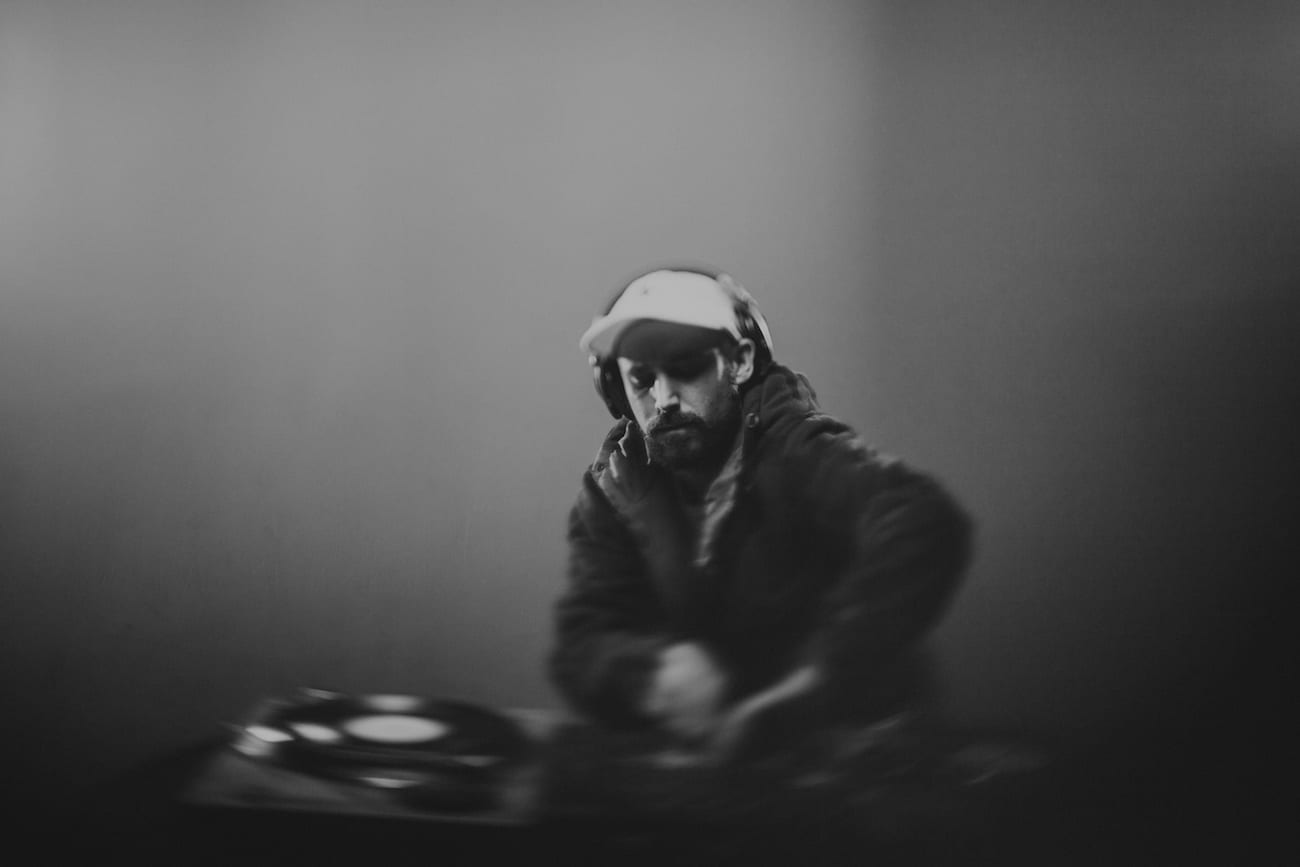 Facebook Live Video Black and white of a DJ wearing headphones doing DJ work