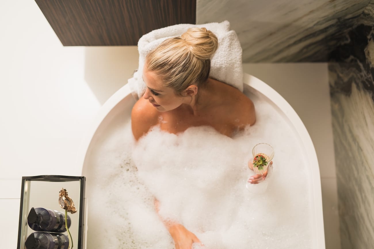 HauteHouse Brands Theorie and Sedu Woman in a bubble bath with a glass of champagne