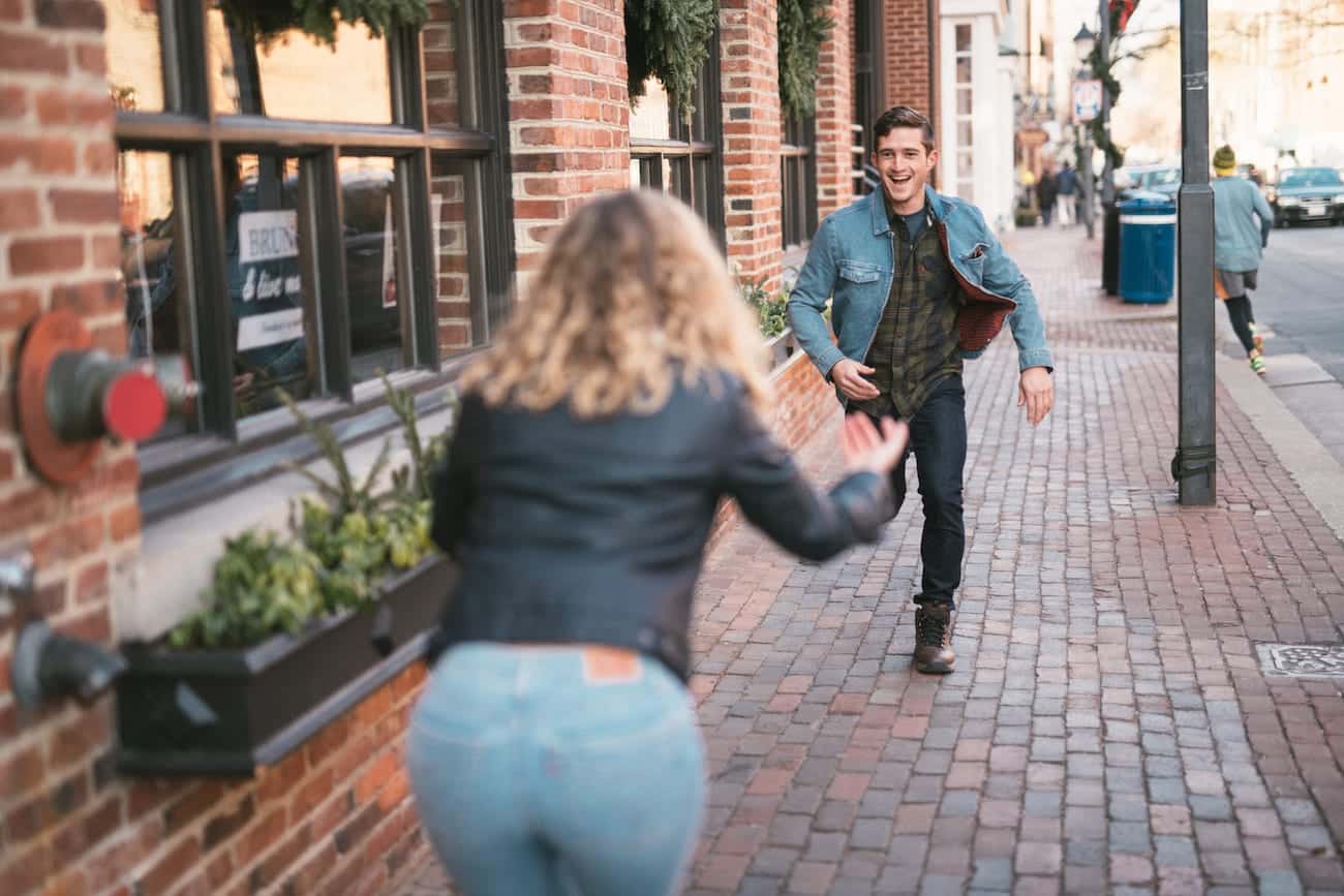 Man running towards woman on a city street