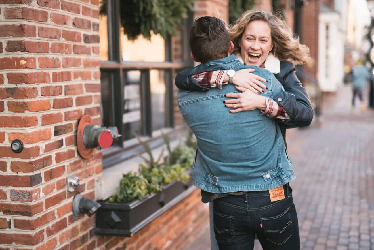 Man and woman hugging each other on a city street