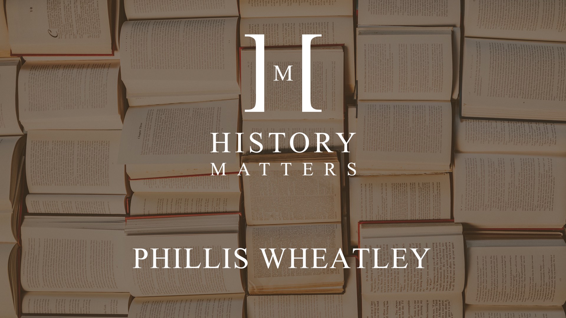 White HM Phillis logo with dimmed background of a bunch of opened books on display