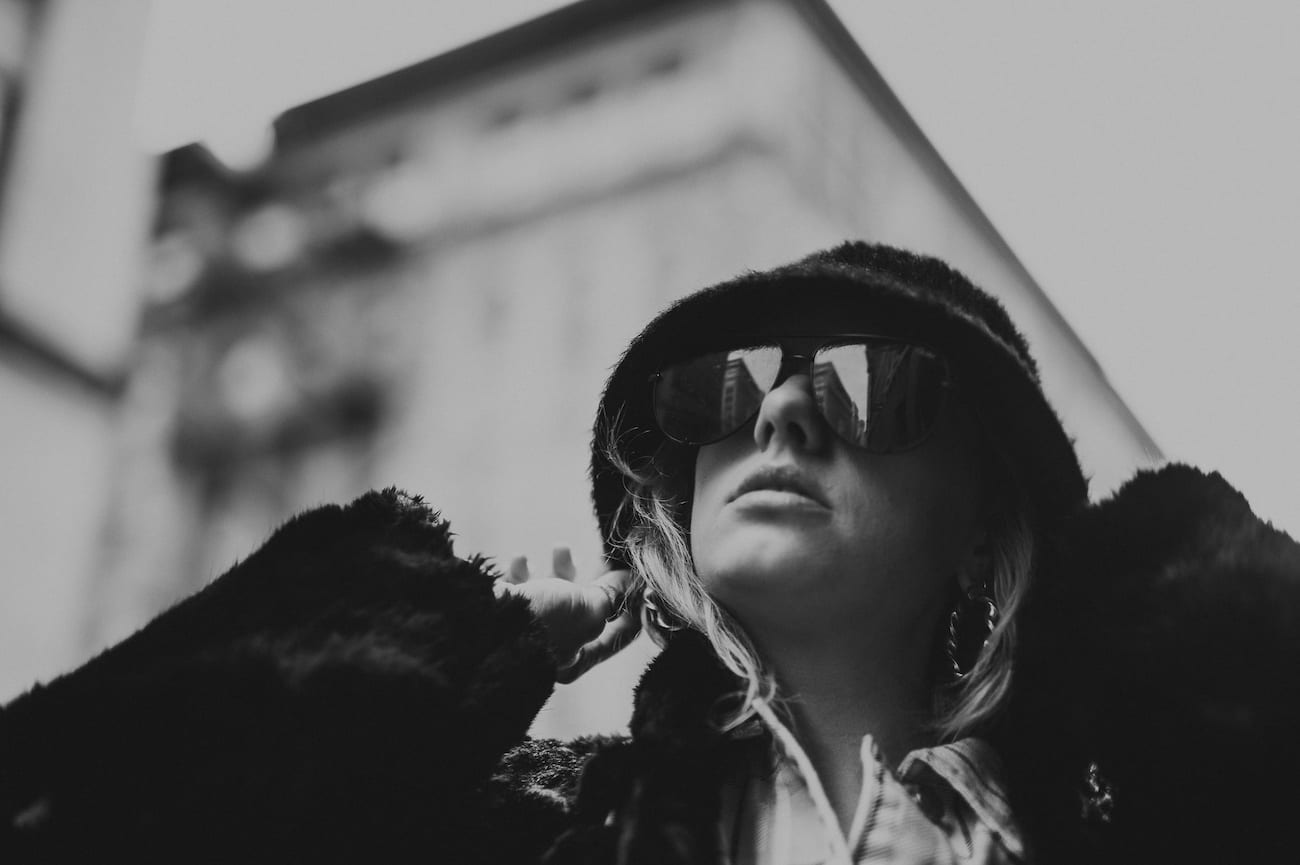 NYFW Off-White Clothing Black and white closeup of woman wearing a hat and sunglasses posing for the camera