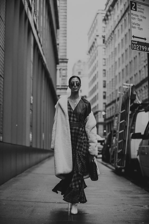 NYFW Off-White Clothing Black and white of woman walking down a city street wearing plush coat