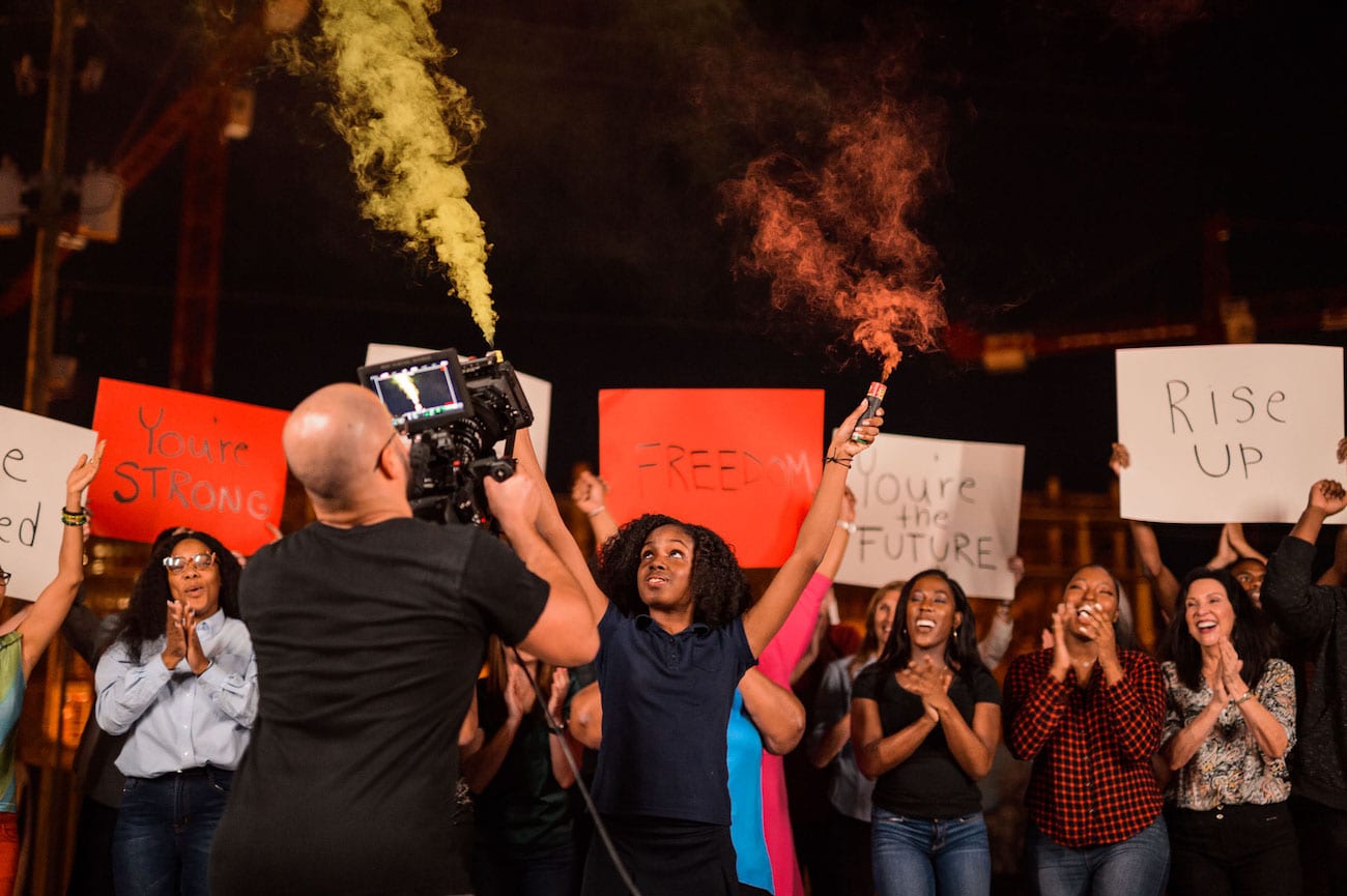 OneUnited BTS 46 Advertising Agency in Fort Lauderdale Group of protesters holding placards with one holding red and yellow color smoke cannisters
