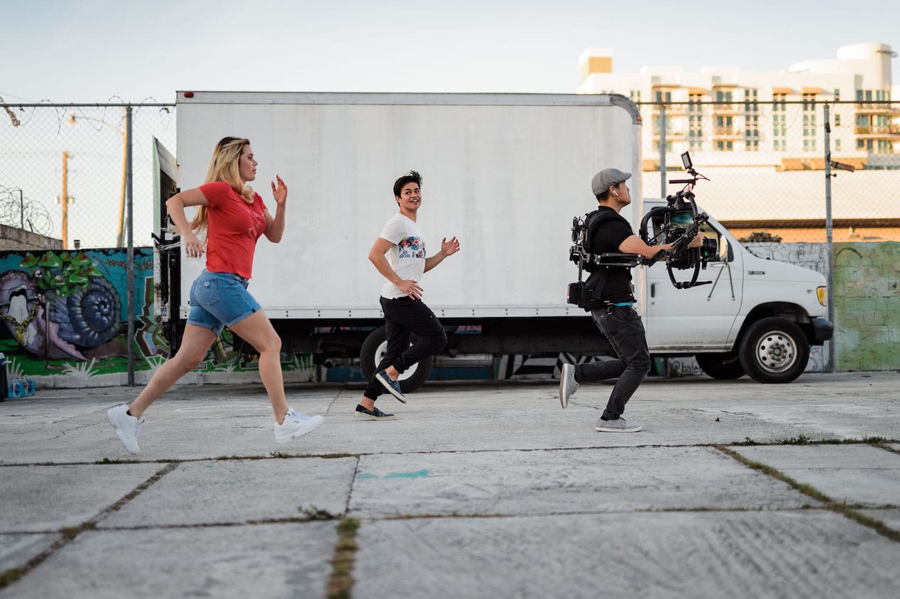 OneUnited BTS 6 Advertising Agency in Fort Lauderdale Group of people running in front of a box car with a video cameraman amongst them