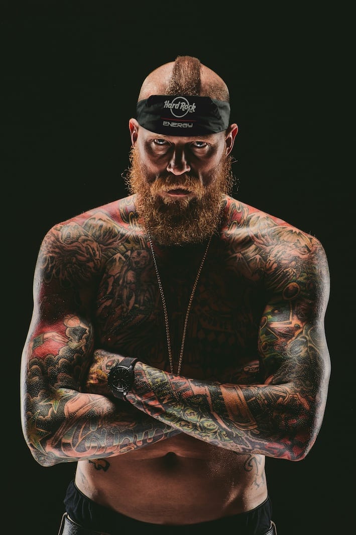 Hard Rock Energy, Marketing by C&I Studios Bearded tattooed man posing for camera with arms crossed with a mohawk