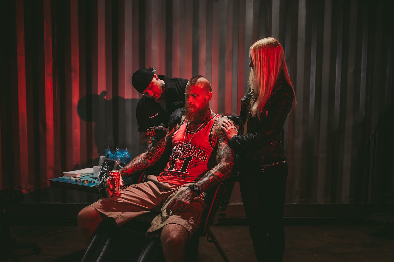 Hard Rock Energy Marketing by C&I Studios Bearded tattooed man holding Hard Rock Energy drinks with tattoo artist working on a tattoo with an assistant standing nearby