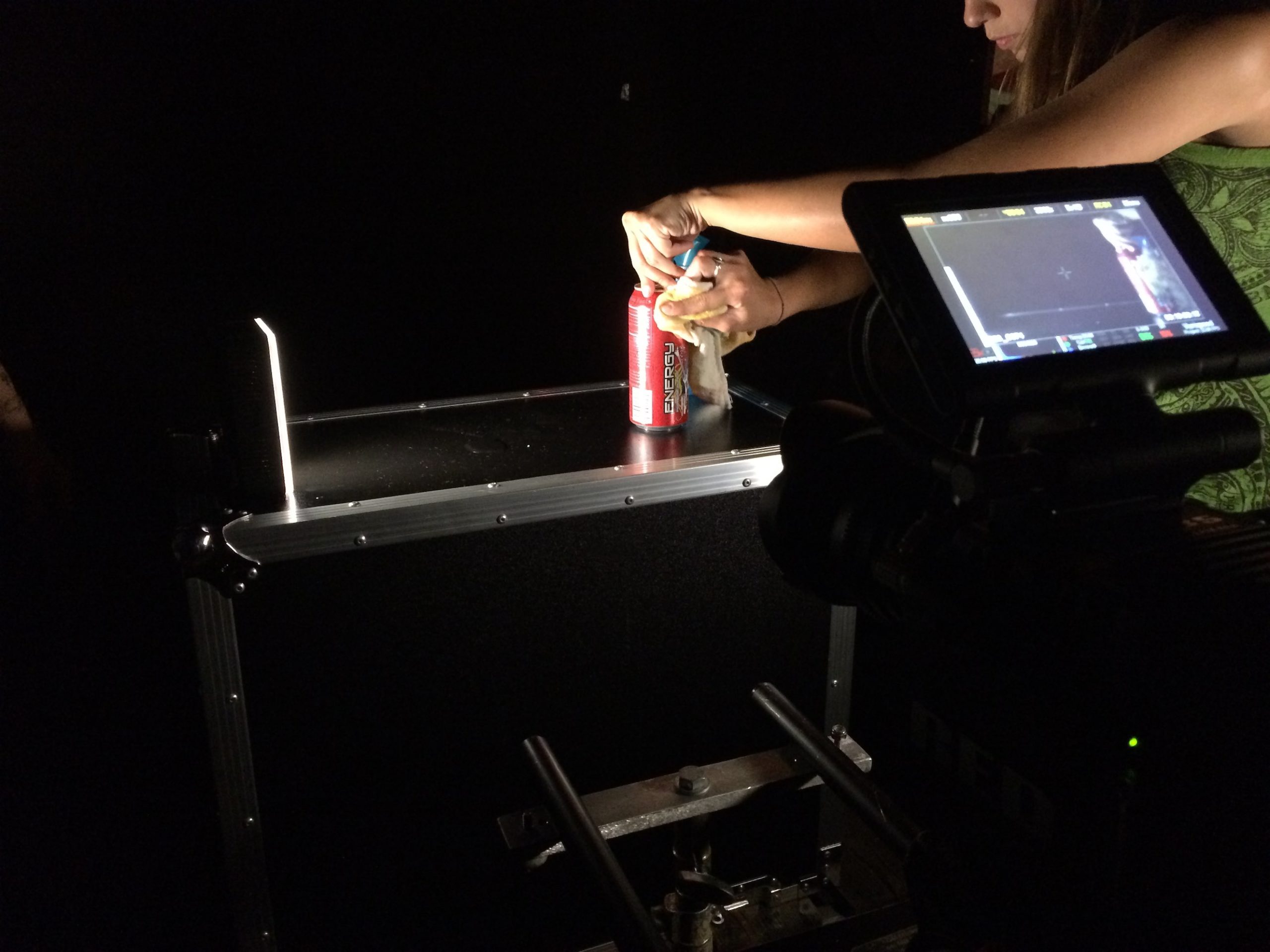 IU C&I Studios Portfolio Hard Rock Energy BTS Woman opening a can of Hard Rock Energy drink surrounded by equipment