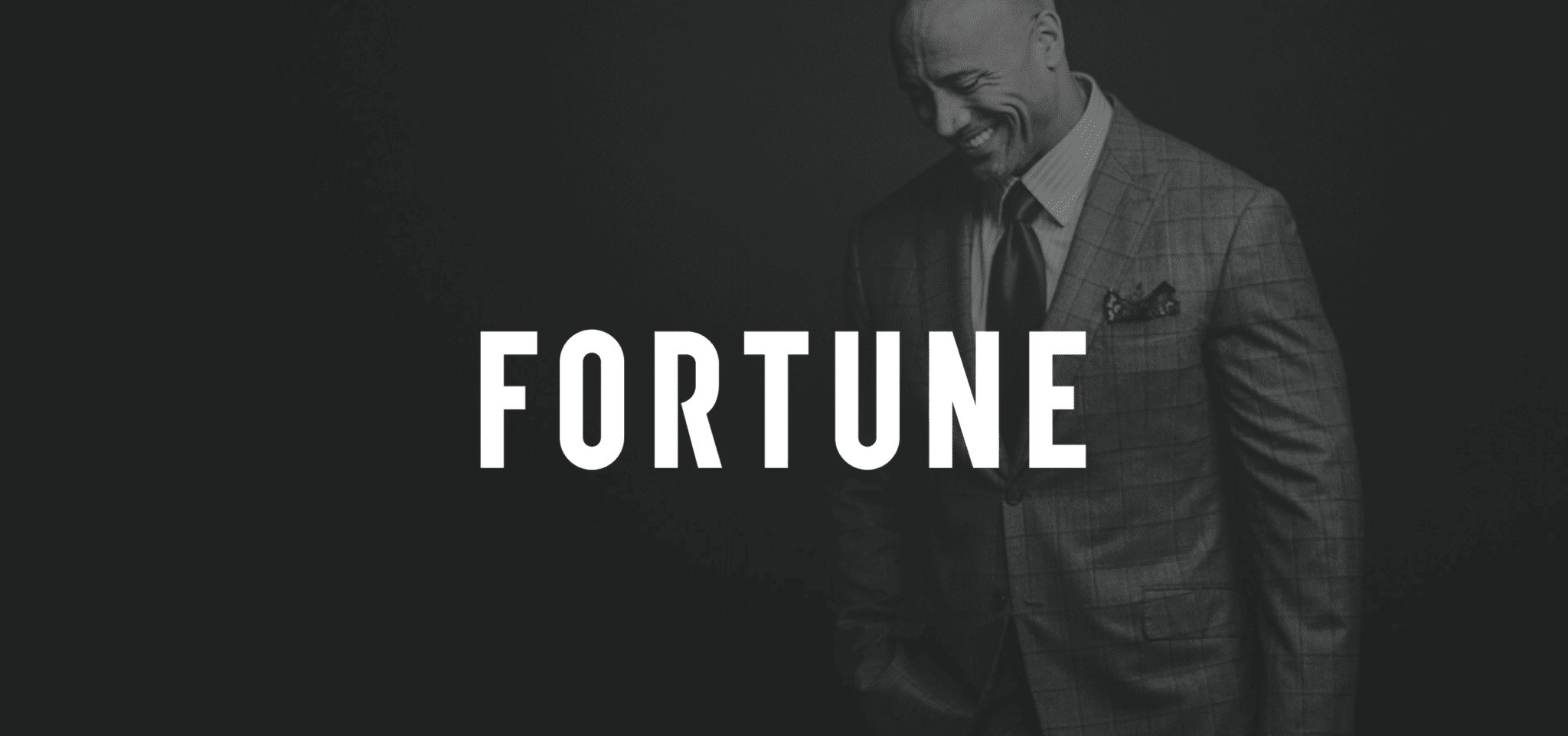 Black and white of white Fortune logo with Dwayne "The Rock" Johnson with Fortune Magazine in the background posing for camera looking down and smiling