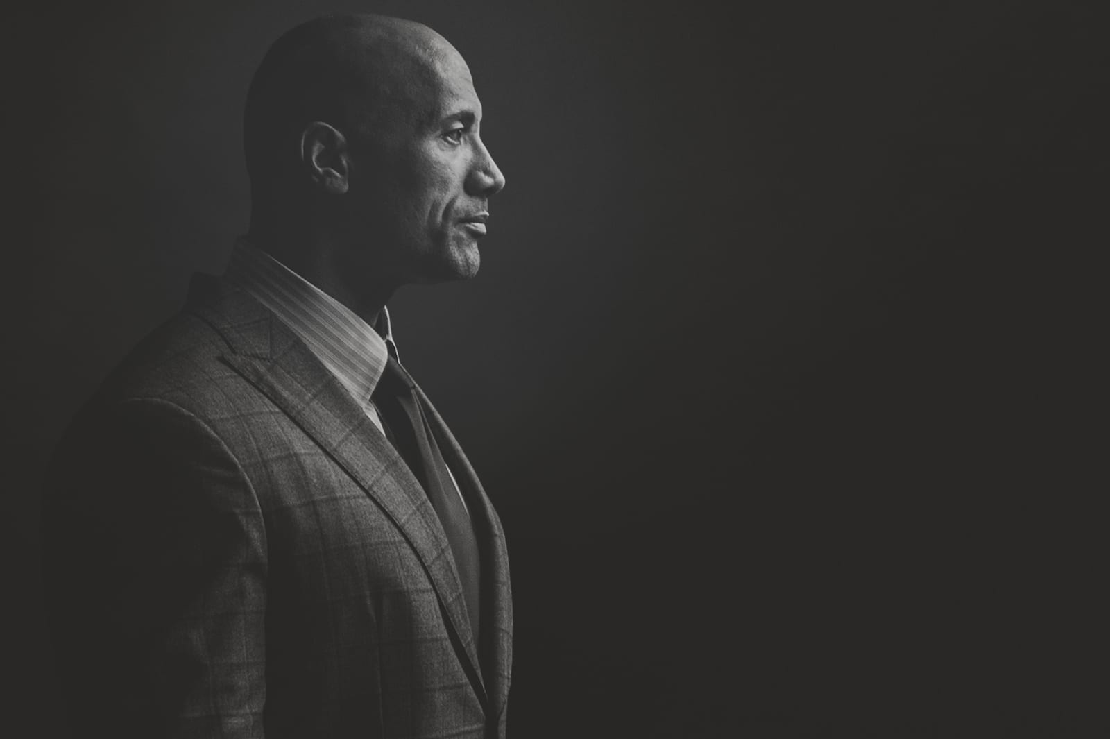 Black and white side profile of Dwayne "The Rock" Johnson with Fortune Magazine posing for the camera