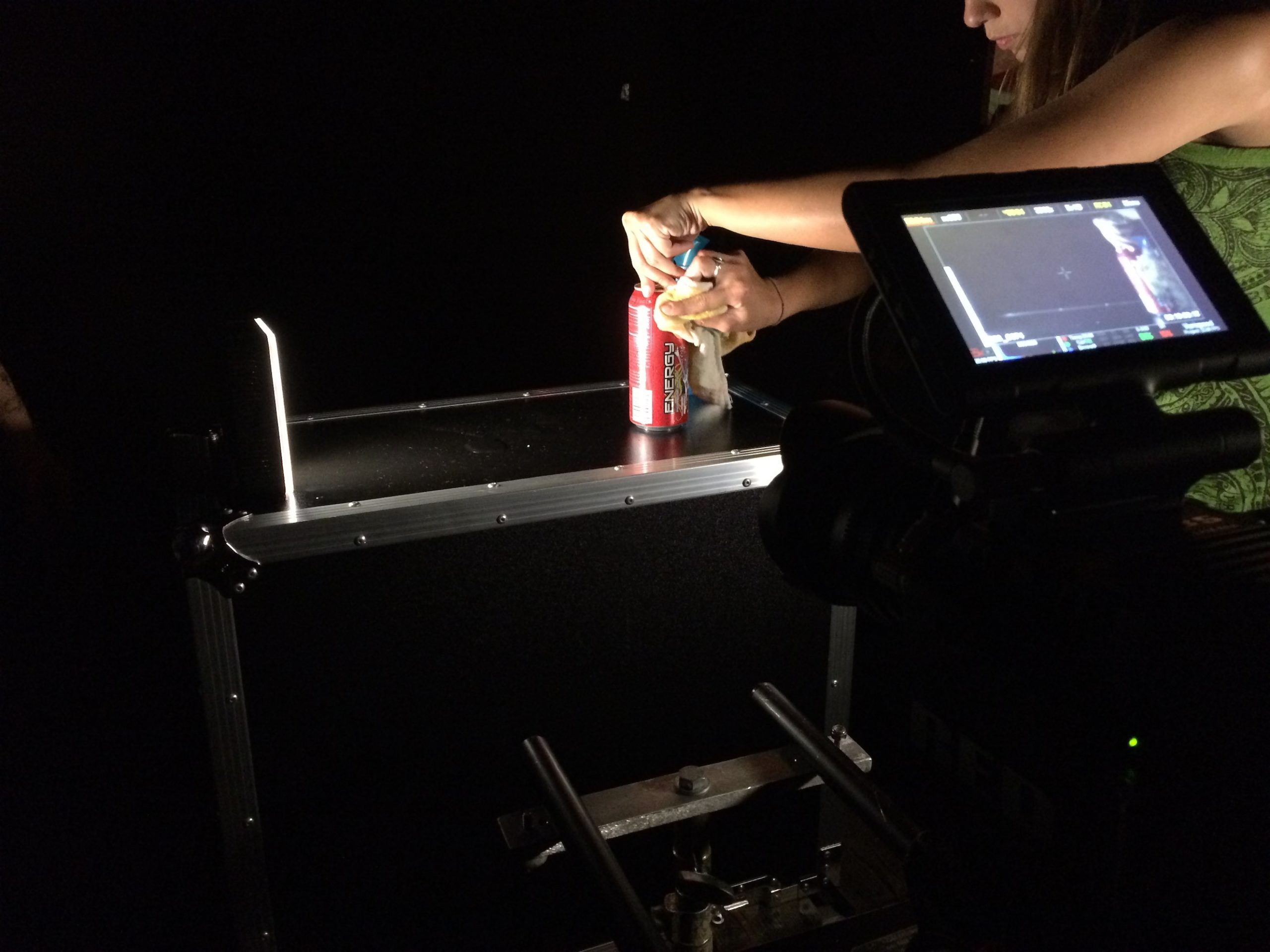 Woman opening a can of Hard Rock Energy drink surrounded by equipment