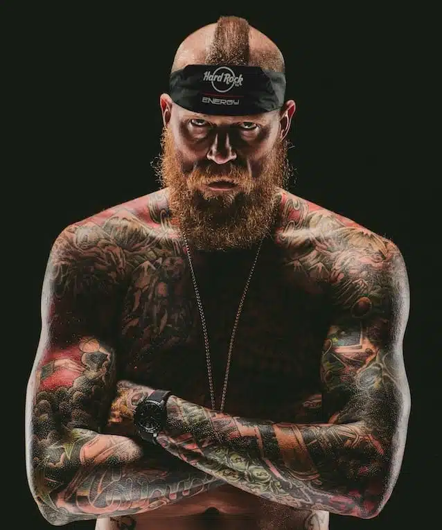 Hard Rock Energy 11 Bearded tattooed man posing for camera with arms crossed
