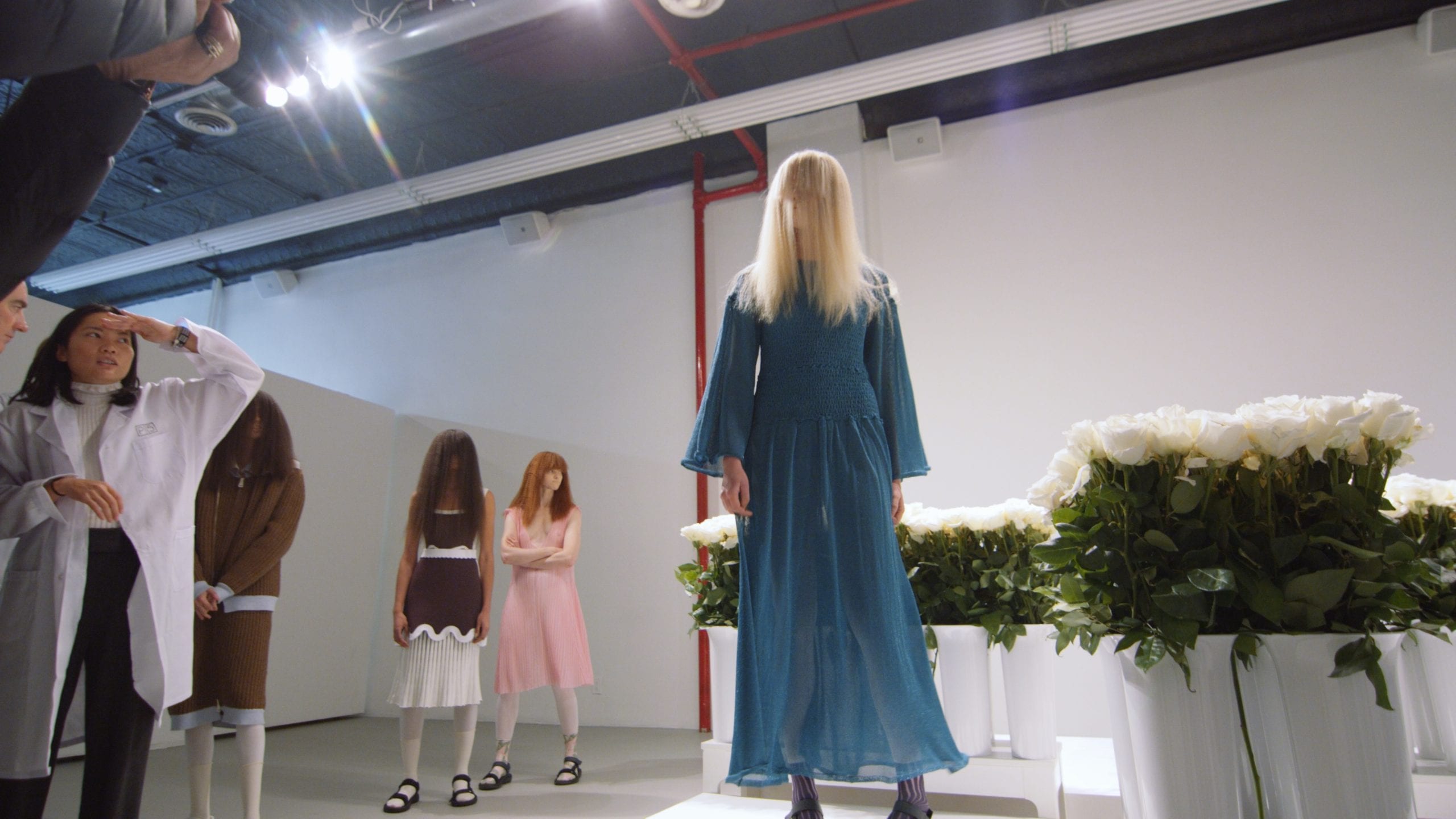 393 NYC hosts PH5 fashion event-Multiple females at a fashion show. One wearing a blue see through dress with long blond hair partially covering face posing for camera.