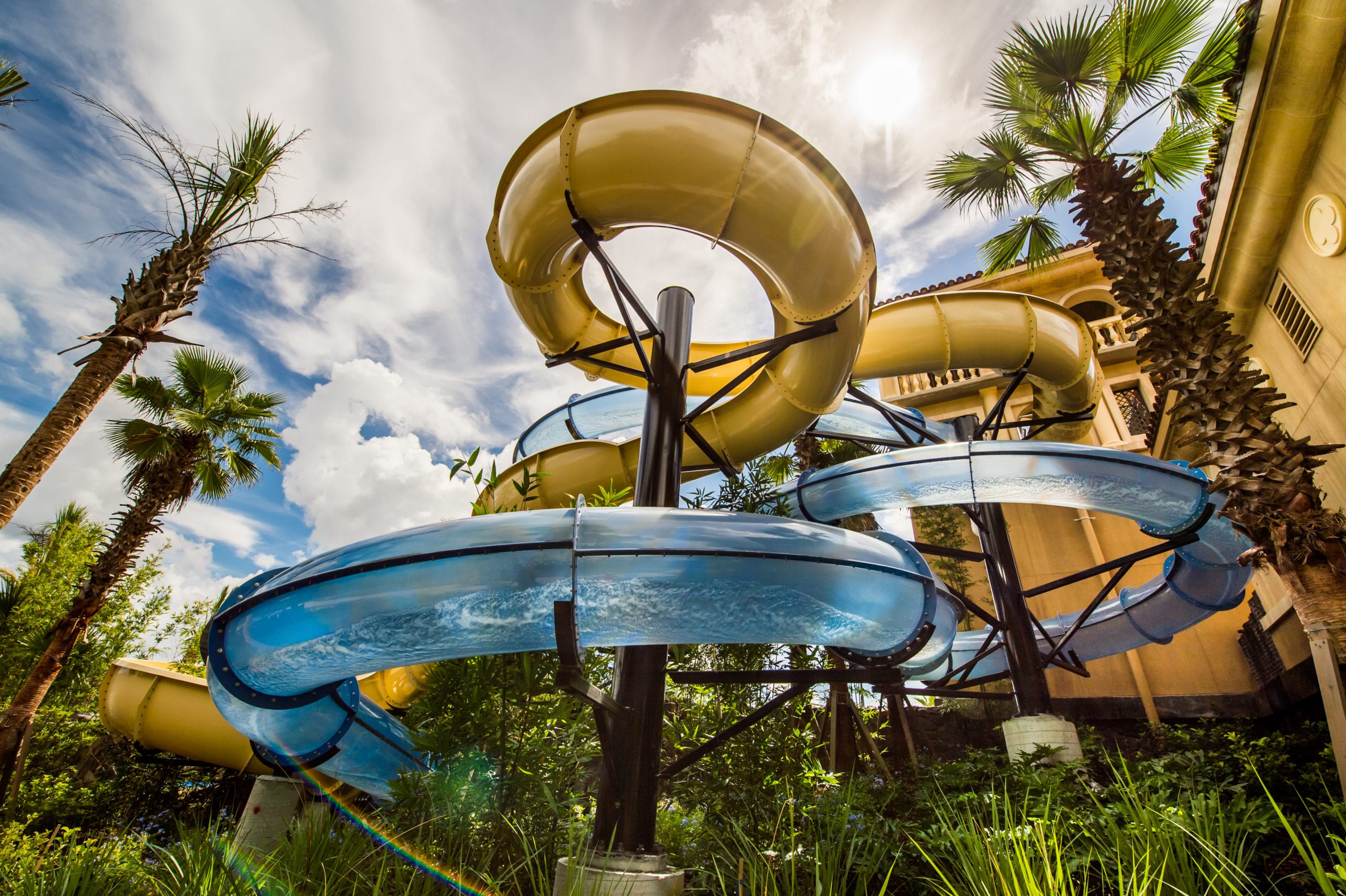 Four Seasons Building with a water slide nearby surrounded by palm trees
