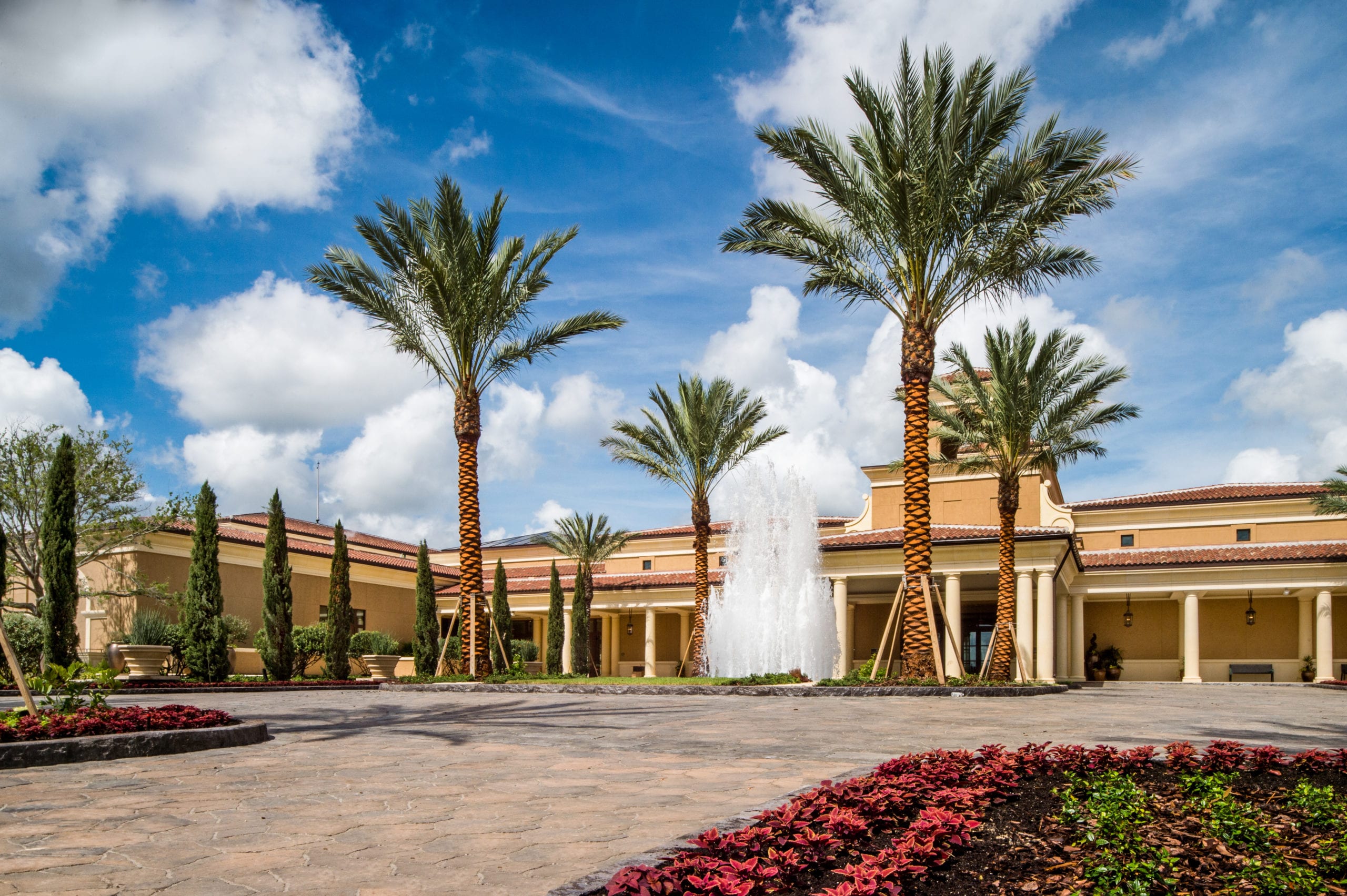 Four Seasons Building with walkway, trees and palm trees with fountain