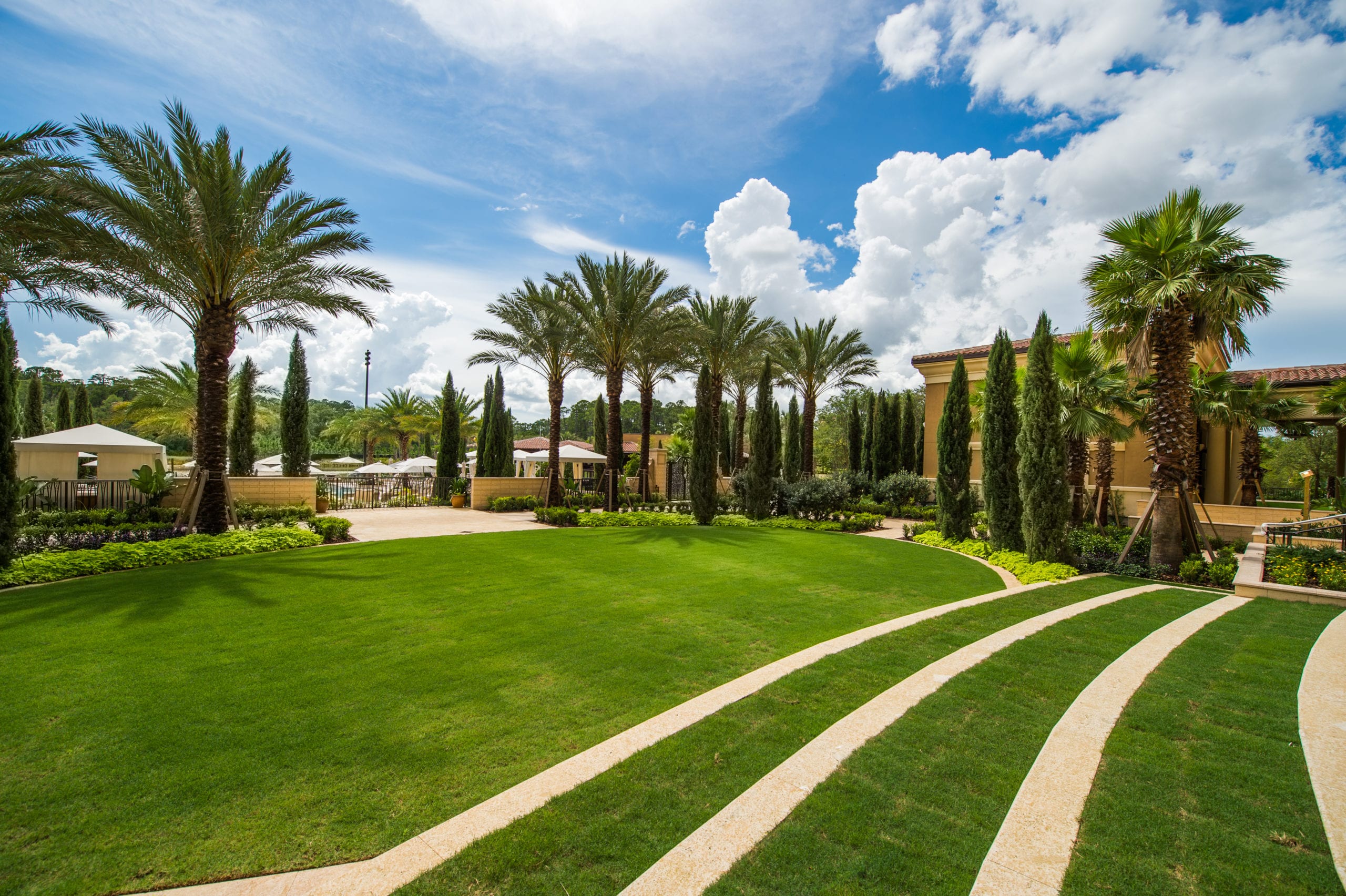 IU C&I Studios Portfolio Four Seasons Building with green lawns, trees and palm trees