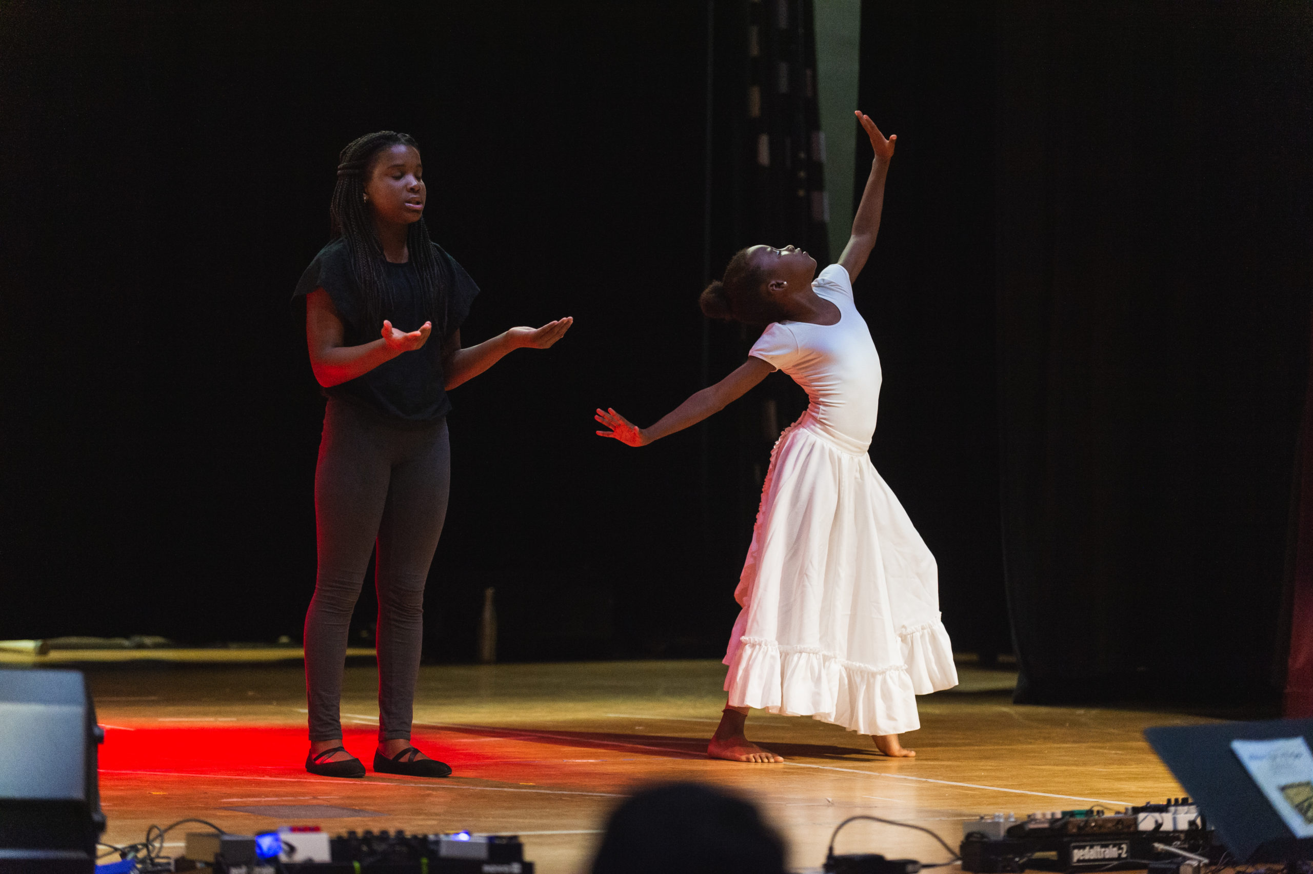 The Kennedy Center Young woman performing on a stage in white dress with another young woman in a black and gray outfit